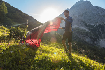 Austria, Tyrol, Hiker setting up his tent in the mountains