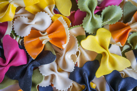 Mixed set of dry multi-colored Italian pasta on a white old wooden box. Background. Close up.