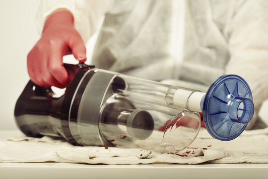 Specialist with micro traces vacuum cleaner getting evidences for analysis