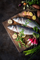 fish sea bass with vegetables potatoes, garlic and herbs, ingredients for cooking