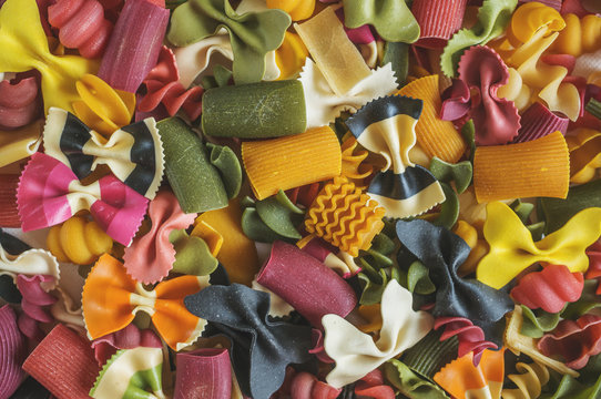 Mixed set of dry multi-colored Italian pasta on a white old wooden box. Background. Close up