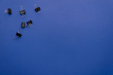 Binder clips in the up-left corner of a blue background