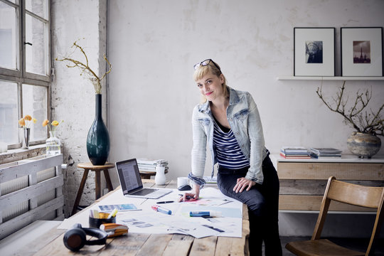 Smiling woman at desk in a loft
