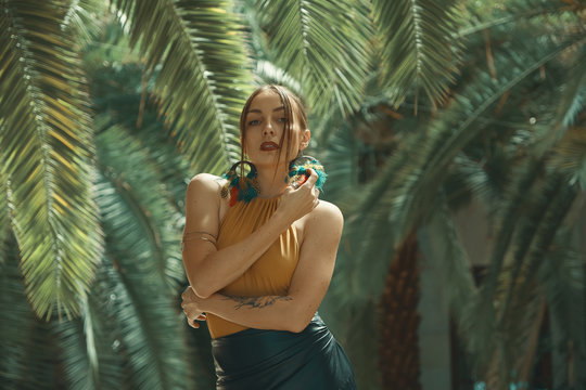 Stunning fit woman among tropical plants posing