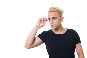 handsome trendy young guy in a black shirt on a white background. straightens glasses