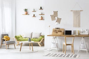 Simple home office with a desk and living room interior decorated with macrame and plants