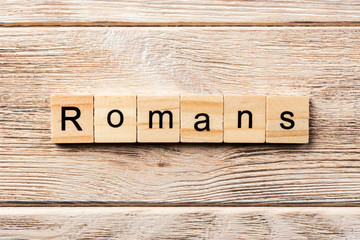 romans word written on wood block. romans text on table, concept