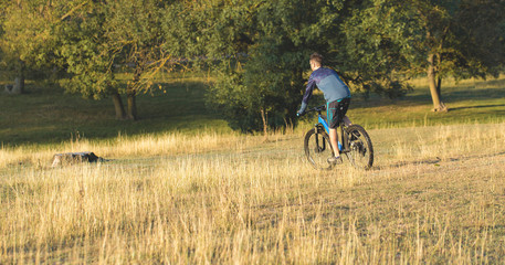 A cyclist rides the hills, Beautiful portrait of a guy on a blue bicycle