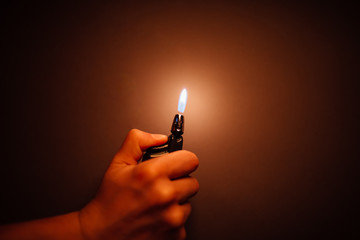 cigarette lighter igniting by a hand - obrazy, fototapety, plakaty