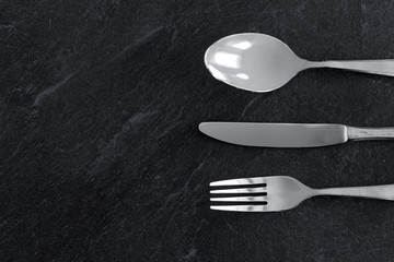 table setting, cutlery and eating concept - close up of fork, knife and spoon