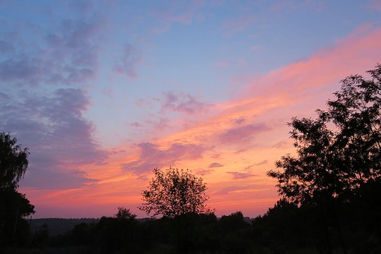 Beautiful pink sunset over the field in europian village