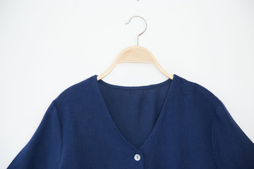 Blue colour blouse is clothes hanger on white background.