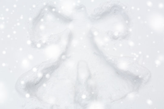 winter holidays and christmas concept - angel silhouette or print on snow surface