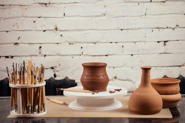 close up dirty hands of a man woman potter, creating an clay earthen jar pot on the potter's wheel...