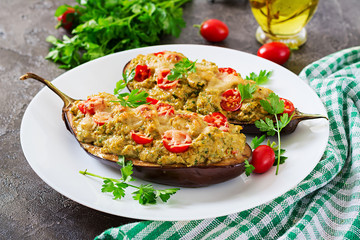 Minced meat chicken and vegetables stuffed eggplants on a grey background. Dinner food.