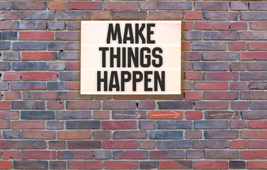 Fototapeta na wymiar Make Things Happen message on Brick wall with light box