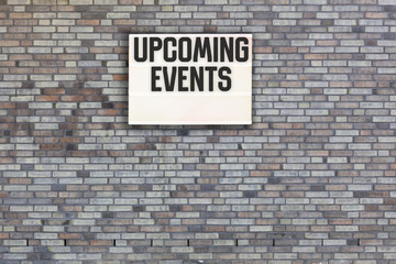 Fototapeta na wymiar Upcoming Events message on Brick wall with light box