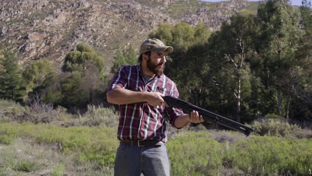 man shooting shotguns at clay pigeon outdoors