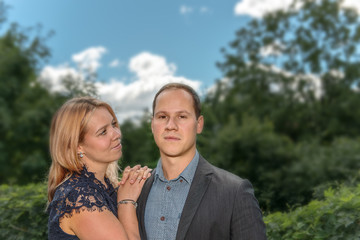 A young couple, man and woman, standing outdoors and looking happy. Concept: love and happiness or family