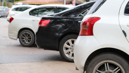 Closeup of rear side of white car park in parking area.