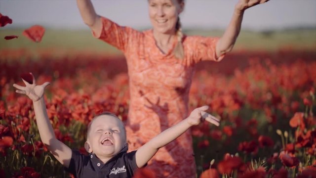 Mother and son running in field of poppies in Denmark