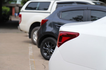 Closeup of rear side of white car park in parking area.