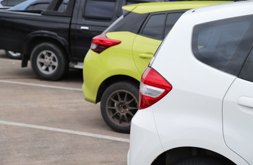 Closeup of rear side of white car park in parking area.