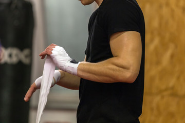 Boxer athlete wears hand protection in training in the gym