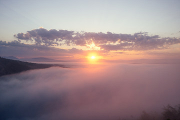 sunrise clouds on top of rocky mountain with misty ,mist peaks sunset landscape.