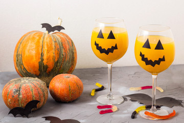 Autumn orange holiday pumpkin cocktail with halloween decor on the table