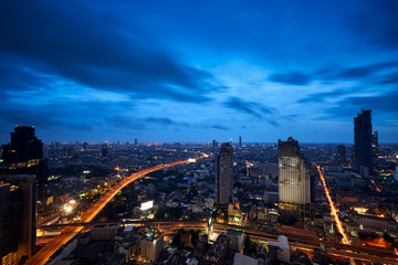 twilight skyline and light tail on expressway in cityscape metropolis