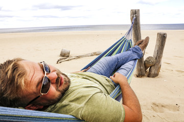 Beach and sea landscape with man on hammock. 