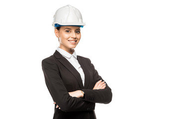 beautiful young female architect in helmet and suit looking at camera with crossed arms isolated on white