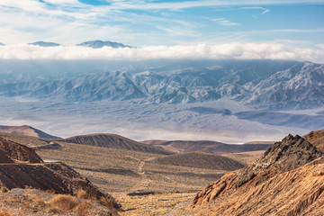 Beautiful scenic mountain overview of Death Valley, California , US.  Desert plain with hill, roads, mountain ridges and clouds. 