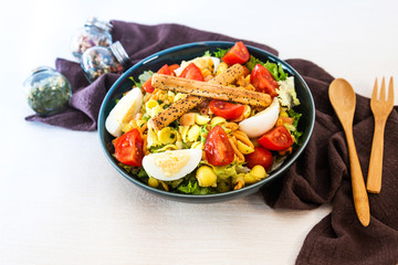 Salad of pasta, egg, smoked salmon tartare, salad and tomato, with a citrus vinaigrette sauce.