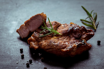 Grilled beef steak with spices on black Stone Table