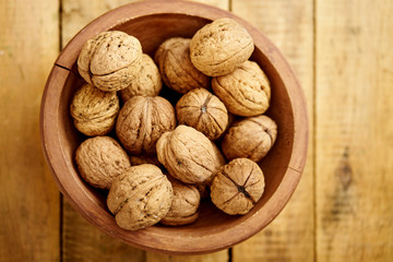 bowl full of delicious and fresh walnuts on an old wooden table