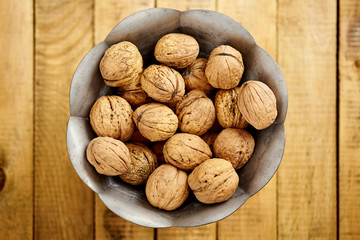 bowl full of delicious and fresh walnuts on an old wooden table