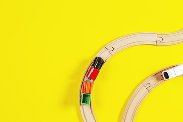Toy trains and wooden rails on yellow and blue color background
