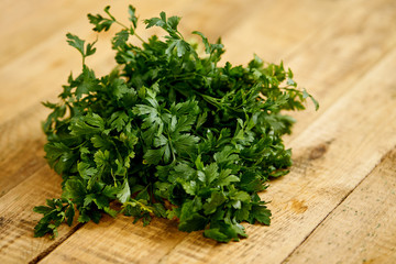 bunch of fresh green parsley on an old wooden kitchen table
