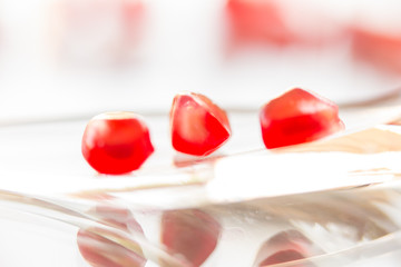 pomegranate seeds on glass plate and on white background