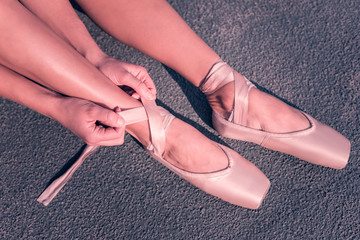 Almost ready. Professional ballet dancer fastening her pointe shoes while getting ready to the performance © Viacheslav Yakobchuk