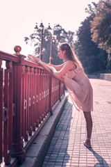 Professional dancer. Nice positive woman putting her leg on the bridge while developing her flexibility © Viacheslav Yakobchuk