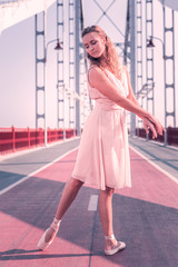 Ballet dancer. Pleasant attractive woman standing on the bridge while having a performance there © Viacheslav Yakobchuk
