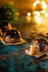 small ricotta cakes with chocolate icing, in Christmas atmosphere. Christmas lights in the background 