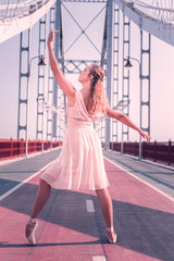 Dancing pose. Nice beautiful woman holding her leg up while standing in the dancing pose © Viacheslav Yakobchuk