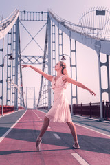 Beauty in movements. Pleasant attractive ballerina practicing her dance while standing on the bridge © Viacheslav Yakobchuk