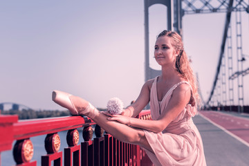 Very flexible. Attractive nice woman putting the leg on the parapet while showing her excellent flexibility © Viacheslav Yakobchuk