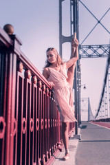 Outdoor training. Pleasant nice ballerina standing near the parapet while having an outdoor training © Viacheslav Yakobchuk