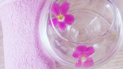Fototapeta na wymiar Romantic composition with a candle and violet flowers floating in a bowl of water.The concept of Spa,cosmetic,procedure,treatment.